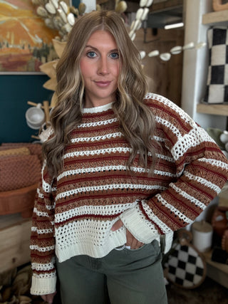 Woman wearing the Sunset Drive relaxed fit open-knit sweater in rust, camel and ivory.