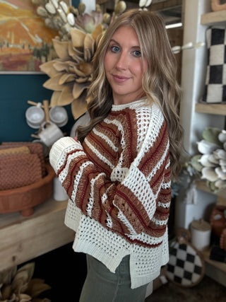 Woman wearing the Sunset Drive relaxed fit open-knit sweater in rust, camel and ivory.