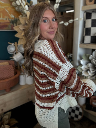 Woman wearing the Sunset Drive relaxed fit open-knit sweater in rust, camel and ivory.