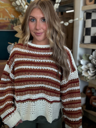 Woman wearing the Sunset Drive relaxed fit open-knit sweater in rust, camel and ivory.