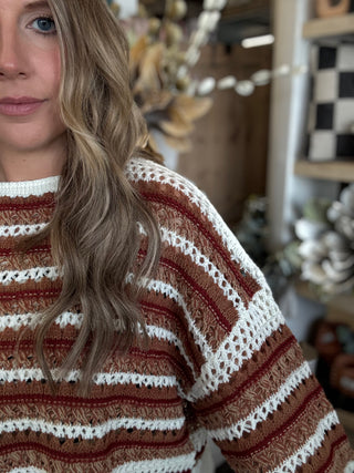Woman wearing the Sunset Drive relaxed fit open-knit sweater in rust, camel and ivory.