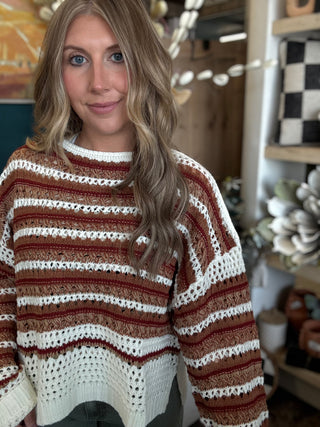 Woman wearing the Sunset Drive relaxed fit open-knit sweater in rust, camel and ivory.