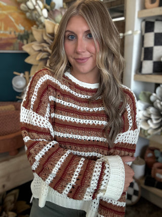 Woman wearing the Sunset Drive relaxed fit open-knit sweater in rust, camel and ivory.