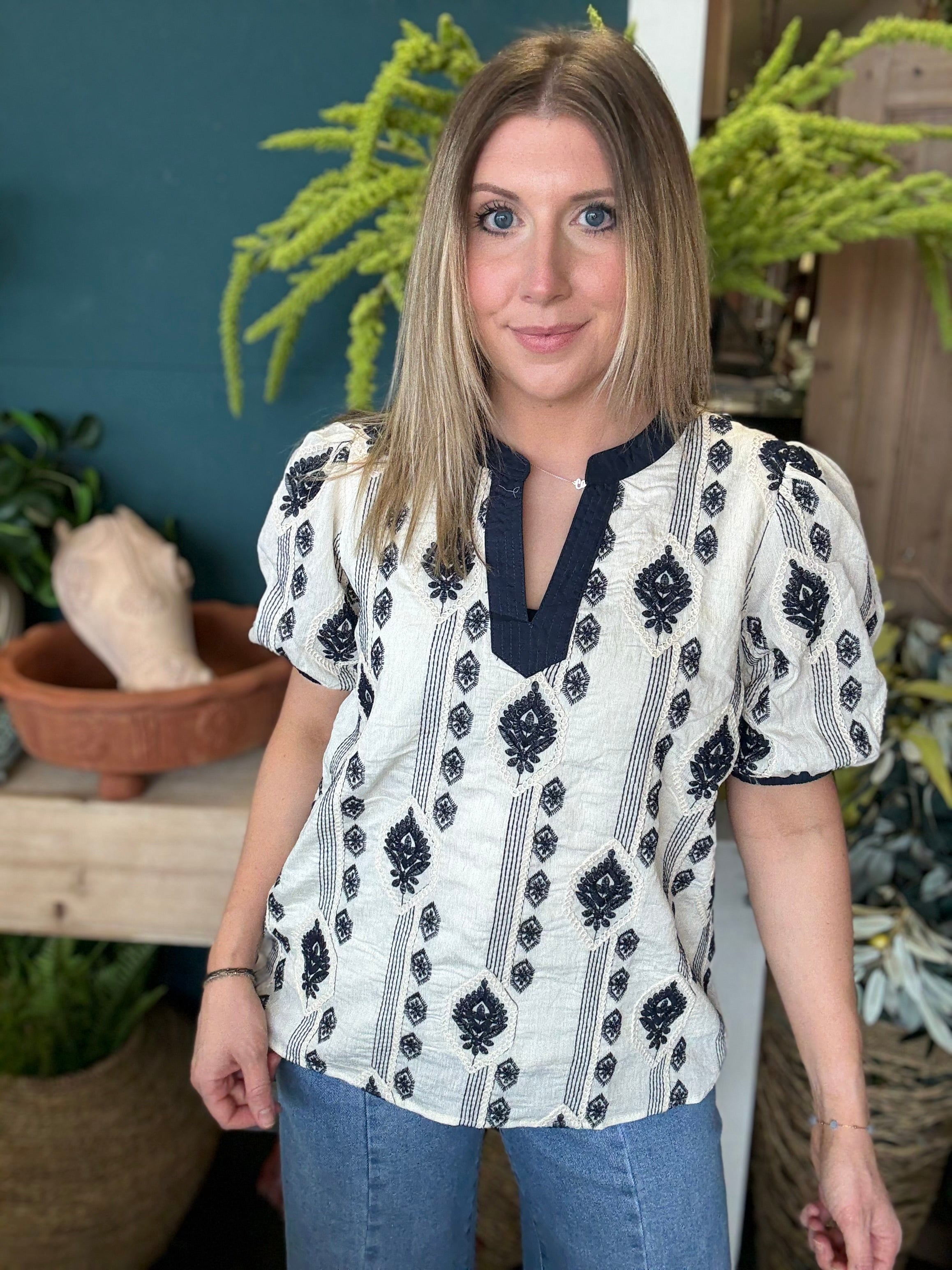 woman wearing boho embroidered split neck boutique blouse with black pattern
