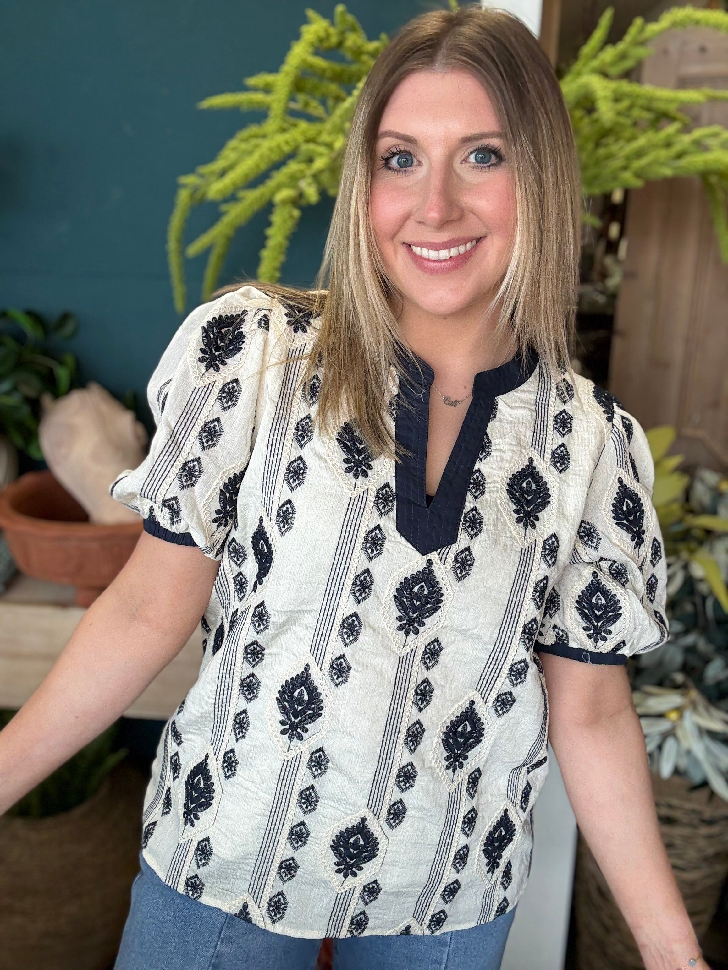 woman wearing boho embroidered split neck boutique blouse with black pattern